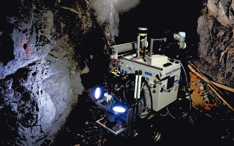 El brazo robótico de Julius agarra una caja de sensor inteligente (derecha) para colocarla en la mina.